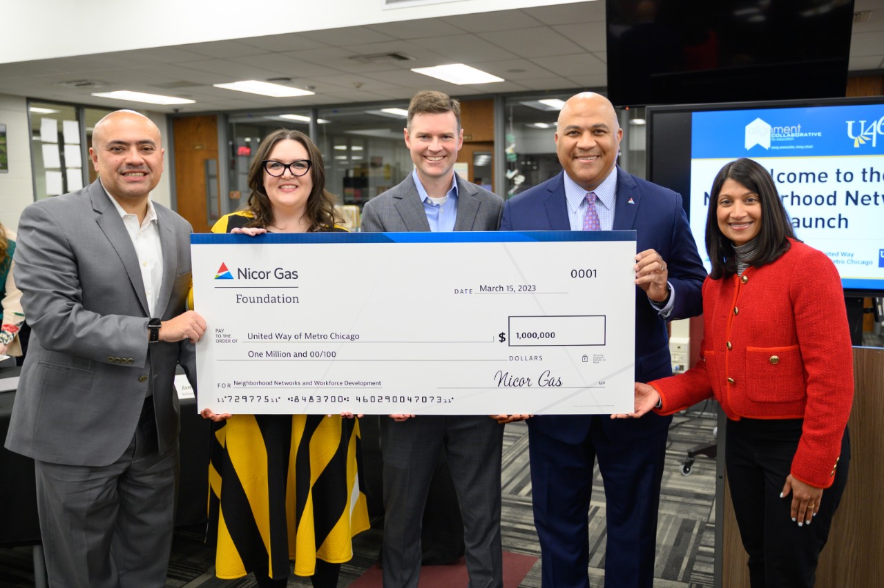 group of people holding large donation check
