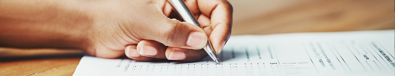 woman writing on paper with pen