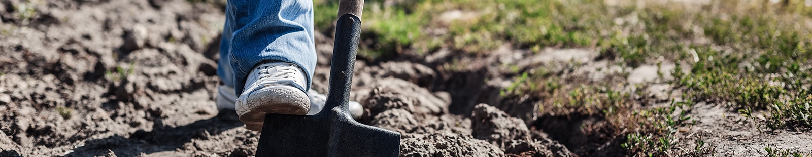 man digging in dirt with shovel