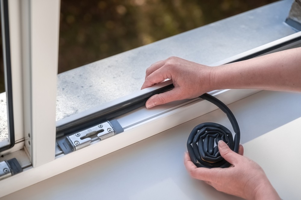 woman sealing a window