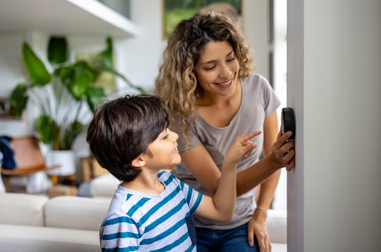 Mother and daughter at smart thermostat